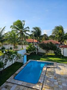 a swimming pool in a yard with palm trees at Pousada Aryanne in Pecém