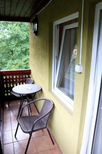 a table and chairs on a porch with a window at Casa Drumetului in Comarnic +7 photos