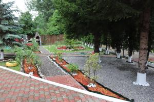 a garden with flowers and trees on a sidewalk at Casa Drumetului in Comarnic