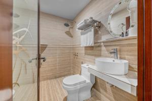 a bathroom with a toilet and a sink and a mirror at Suwara Hotel Kepong KL in Kuala Lumpur