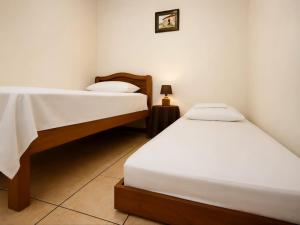 a bedroom with two beds and a lamp in it at Casa Cafetal Aeropuerto in Alajuela