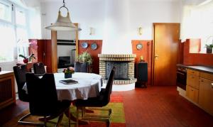 a dining room with a table and a fireplace at Natursteinvilla am Goldberg in Hagen