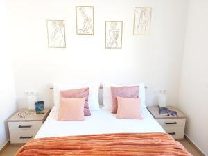 a bedroom with a large white bed with pink pillows at Slano Bay Apartments in Slano