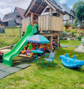 a playground with a slide and play equipment in a yard at U Stenia in Murzasichle