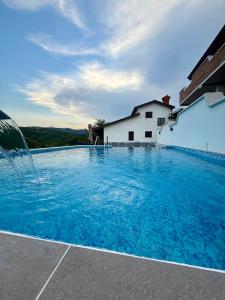 a swimming pool with blue water in front of a building at Turistična kmetija Birsa in Dobravlje