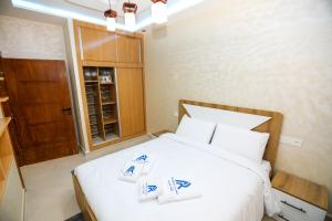 a bedroom with a white bed with two towels on it at Résidence Acharif in Tan-Tan Plage
