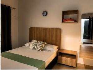 a small bedroom with a bed and a clock on the wall at Hostal Monte Verde in Zaragoza
