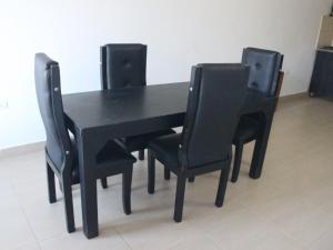 a black dining room table with four black chairs at Hostal Monte Verde in Zaragoza