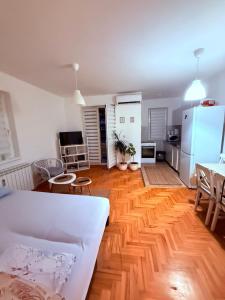 a living room with wooden floors and a white refrigerator at Stari Cerak in Žarkovo