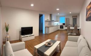 a living room with white furniture and a kitchen at Apartmán Kutička in Prešov