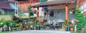 a building with a table and chairs and flowers at U Stenia in Murzasichle +3 photos
