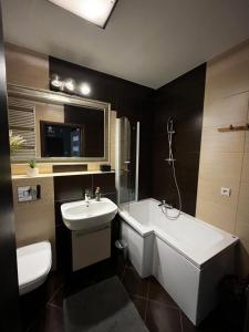 a bathroom with a sink and a tub and a toilet at Cora Lego Apartment City View near Stadium & Sinfonia Varsovia Optional Parking in Warsaw +44 photos