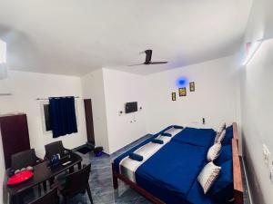 a bedroom with a bed and a table and a desk at The Loop Auroville - High-Speed WiFi & Free Parking, Near Auroville Bakery & Tanto Pizzeria, 5-Minute Drive to ECR & Auroville Beach in Auroville +37 photos