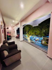a living room with a couch and a large window at The Loop Auroville - High-Speed WiFi & Free Parking, Near Auroville Bakery & Tanto Pizzeria, 5-Minute Drive to ECR & Auroville Beach in Auroville