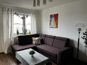 a living room with a couch and a table at Cora Lego Apartment City View near Stadium & Sinfonia Varsovia Optional Parking in Warsaw