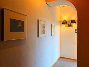 a hallway with two pictures on the wall and two lights at Hotel Orange Kutaisi in Kutaisi
