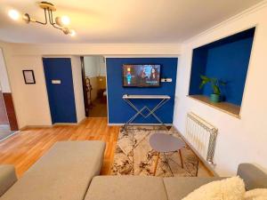 a living room with a couch and a blue wall at Hotel Orange Kutaisi in Kutaisi