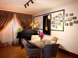 a dining room with a table and a piano at Hotel Orange Kutaisi in Kutaisi