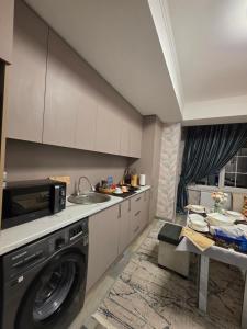 a kitchen with a washing machine and a sink at Apartment with FREE Massage chair Fergana in Fergana