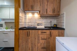 a kitchen with wooden cabinets and a sink at Adali Aparts in Side +9 photos