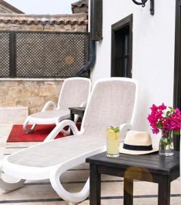 a group of white chairs on a patio with a table at Morea Kaleiçi-Adults Only in Antalya