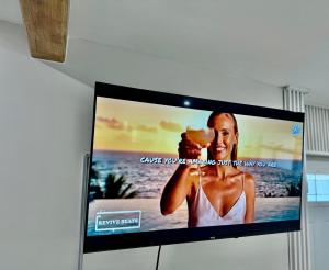 a flat screen tv sitting on a wall at Wood & White in Hialeah