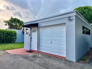 a garage with a white door and a driveway at Wood & White in Hialeah