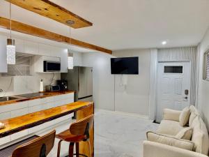 a kitchen with a counter and chairs in a room at Wood & White in Hialeah