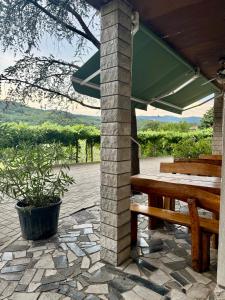 a picnic table and a bench on a stone patio at Turistična kmetija Birsa in Dobravlje
