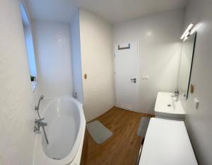 a white bathroom with a tub and a sink at Apartmán Kutička in Prešov +7 photos