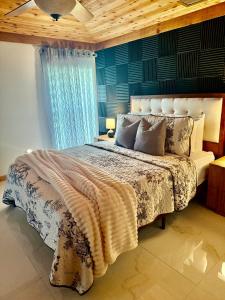 a bedroom with a large bed with a blue wall at Wood & White in Hialeah