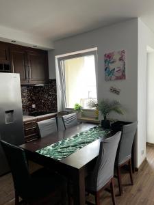 a kitchen with a dining room table with chairs at Cora Lego Apartment City View near Stadium & Sinfonia Varsovia Optional Parking in Warsaw