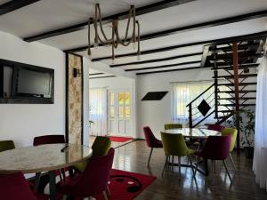 a dining room with two tables and chairs at Casa Ilinca Bran in Şimon