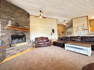 a living room with leather furniture and a brick wall at Cozy Beaver Lake Getaway in Lowell +32 photos