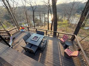 a wooden deck with a table and chairs on it at Cozy Beaver Lake Getaway in Lowell