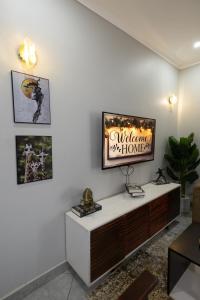 a living room with a tv on a white wall at Luxury & modern 1 Bedroom apartments in Munyonyo-Kampala in Kampala +7 photos