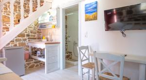 a room with a desk and a tv on a wall at Rodakas Rooms-Pelagia in LivadhokhÃ³rion +18 photos