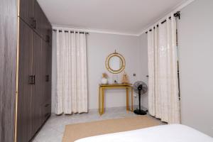 a bedroom with a bed and a table with a mirror at Luxury & modern 1 Bedroom apartments in Munyonyo-Kampala in Kampala