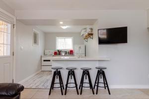 a kitchen with three bar stools in front of a counter at Westlake Cottage - Hillier Lodge in Wellington +8 photos