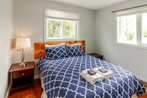 a bedroom with a blue and white bed with towels on it at Westlake Cottage - Hillier Lodge in Wellington