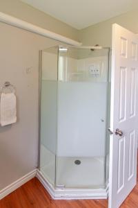 a shower stall with a glass door in a bathroom at Westlake Cottage - Hillier Lodge in Wellington