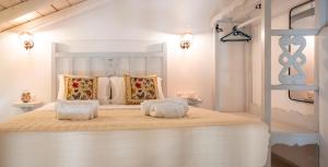 a white bedroom with a large bed with two pillows at Rodakas Rooms-Danae in LivadhokhÃ³rion