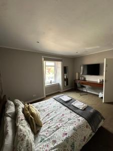 a bedroom with a bed and a television in it at Rooms at 31 in Stonehaven