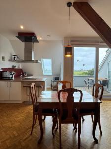 a kitchen and dining room with a table and chairs at Deichoase bei Friesens mit Sauna in Barsfleth