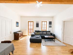 a living room with a couch and a ceiling fan at KAISERLICH WOHNEN zentral und am Fluss in Bad Ischl