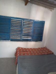 a bedroom with blue shuttered windows and a bed at Casa Catarina in São Roque