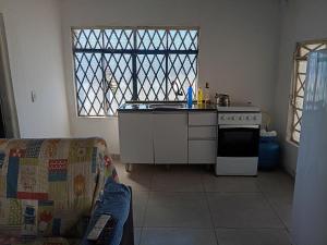 a kitchen with a stove and a couch and a window at Casa Catarina in São Roque