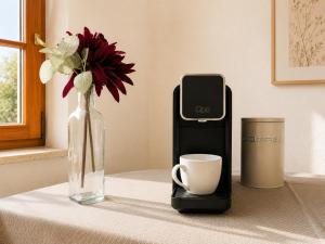 a table with a cell phone and a vase with a cup at KAISERLICH WOHNEN zentral und am Fluss in Bad Ischl +19 photos
