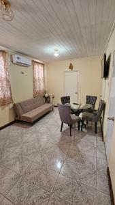 a living room with a couch and chairs and a table at Hidden Bungalow in Roseau