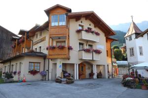 a building with flower boxes on the front of it at Hotel Pordoi - Fam Furgler in Arabba